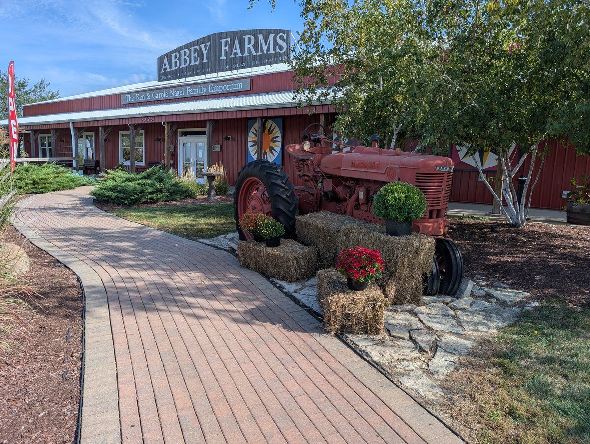 The Abbey Farms storefront with a red tractor parked at the entrance